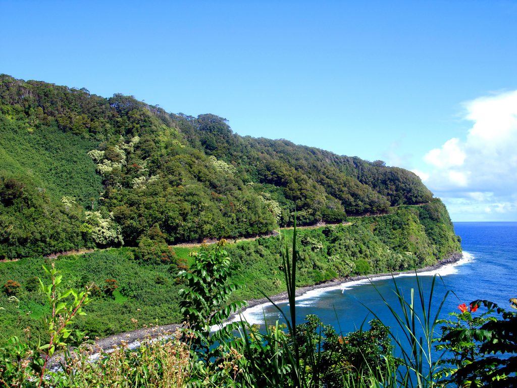 road to hana view of cliffside highway and ocean with green lush mountains lanscape